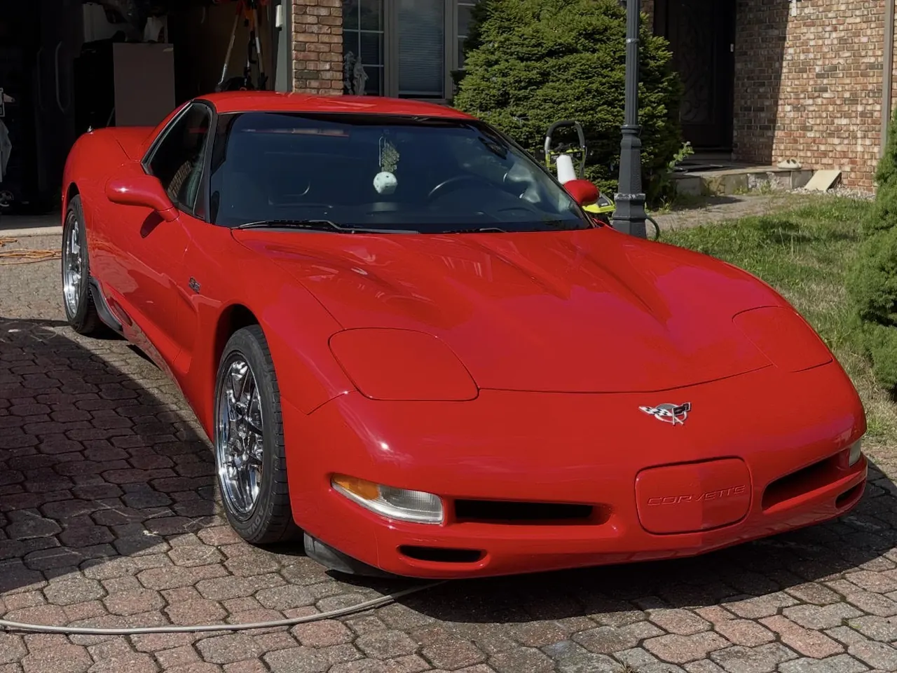 A red Chevrolet Corvette C5 on a brick driveway